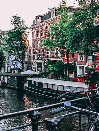 Malerischer Ausschnitt einer Gracht in Amsterdam. Rechts im Bild Blumen.