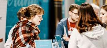 Pressemitteilung: Studienwahlevents für Oberstufenschüler und Abiturienten Eine Besucherin unterhält sich mit Vertretern einer Hochschule auf der Bachelor Messe.