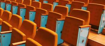 Hochschultypen Mehrere eingeklappte Stühle eines Hörsaals.