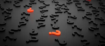 Bachelor Informationswissenschaft Auf einer schwarzen Oberflächen liegen durcheinander angeordnet viele dreidimensionale schwarze Fragezeichen. Zwei von ihnen sind in einem neonorange gestaltet, sodass diese herausstechen.