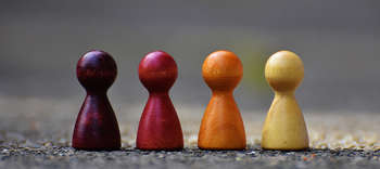 Bachelor-Studiengänge im Fachbereich Kultur- und Gesellschaftswissenschaften. Auf dem Bild sind vier Spielfiguren in verschiedenen Farben abgebildet.