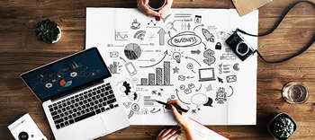 Management Das Bild zeigt einen Arbeitsplatz aus der Vogelperspektive. Auf dem Schreibtisch befinden sich ein Laptop und eine Mindmap.