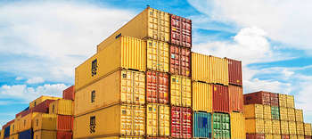 Logistik Auf dem Bild sind viele bunte aufeinandergestapelte Container zu sehen.