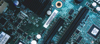 Bachelor Elektrotechnik Das Bild zeigt die Nahaufnahme eines Motherboards. Blau und grün sind die dominierenden Farben.