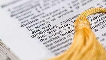 Sprachreisen Englisch Nahaufnahme eines Auschnittes eines englischen Wörterbuches. Im Fokus das Wort DICTIONARY.