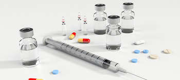 Medizin und Gesundheit Auf dem Bild sind eine Spritze sowie mehrere Pillen, Tabletten und Ampullen zu sehen.