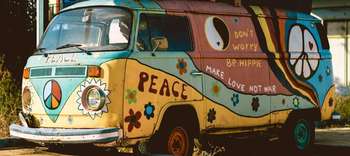 Bachelor Friedens- und Konfliktforschung Foto eines alten VW Busses, welcher bunt bemalt ist. Darauf unter anderem Freidesnzeichen, Blumen und die Aufschrift PEACE.