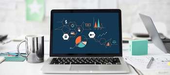 Bachelor Development Studies Ausschnitt eines Schreitisches, auf dem verschiedene Zeichnungen, Grafiken und Dokumente liegen. Inmitten ein Laptop, der Diagramme und weitre grafische Darstellungen zeigt.