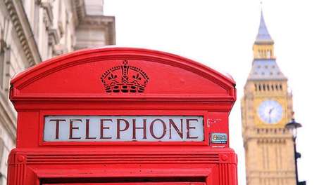 Die spitze einer klassischen englischen Telefonzelle. Rechts daneben der Big Ben.  