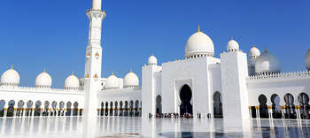 Islamwissenschaft Auf dem Bild befindet sich ein Ausschnitt der Scheich-Zayid-Moschee in Abu Dhabi. Erkennbar ist der feine weiße Marmor und die goldenen Details der Säulen sowie der prunkvolle Eingang.