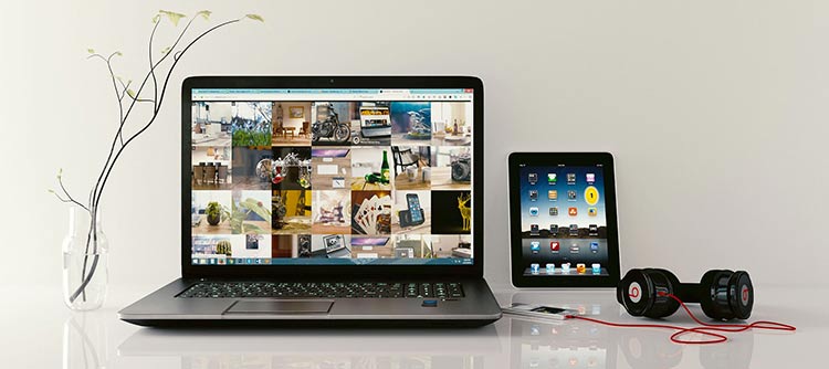 Bachelor Kommunikation Ausschnitt eines weißen glänzenden Schreibtisches. Auf diesem befindet sich ein Laptop, rechts daneben ein Tablet. Vor dem Tablet ein MP3 Player an den Kopfhörer angeschlossen sind.