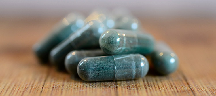 Bachelor Pharmazie Nahaufnahme von Kapsel-Tabletten auf hölzernem Untergrund.