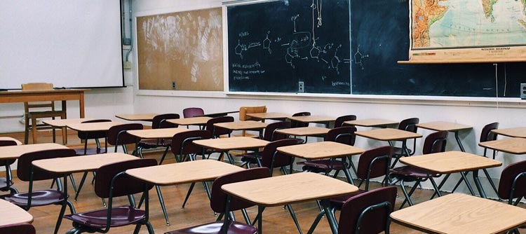 Bachelor Gymnasiallehramt Ausschnitt eines Klassenzimmers mit EInzeltischen. Auf der Tafel sind Strukturformeln aus der Chemie gezeichnet.