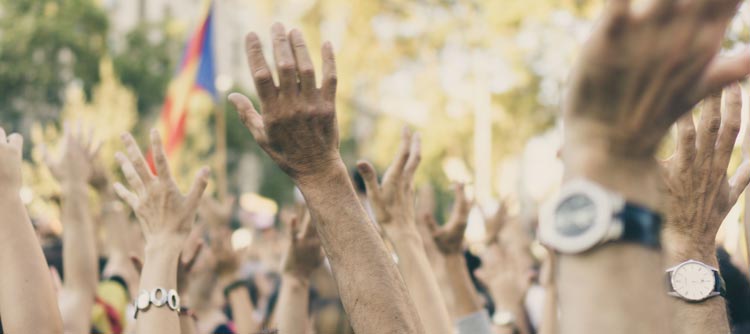 Bachelor Öffentliches Recht Das Bild zeigt eine Menschenmenge. Zu sehen ist ein Ausschnitt der in die Luft gehobenen Arme der Personen. Es erinnernt an eine demonstrationsähnliche Versammlung.