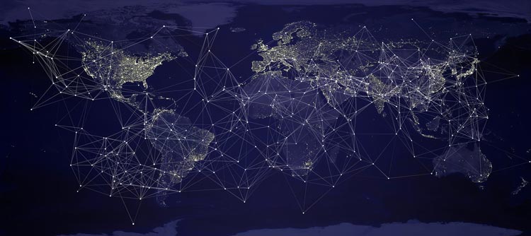 Bachelor Internationale Beziehungen Darstellung einer Weltkarte in der Dunkelheit. Zwischen den Ländern sind viele Netzwerke in Form von Lichtpunkten und -Strahlen dargestellt, die internationale Beziehungen verdeutlichen.