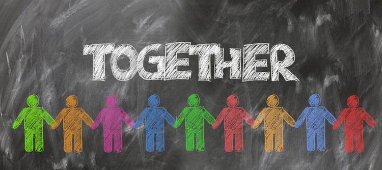 Bachelor Sozialarbeit Kreidezeichnung auf einer Tafel. Zu sehen sind neun bunt gemalte und nebeneinander stehende Personen, deren Hände sich berühren. Über den Personen groß geschrieben das Wort TOGETHER.